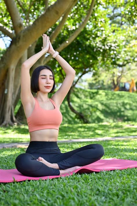 Calm Asian Female Practicing Yoga Breathing Deeply Raising Hands And