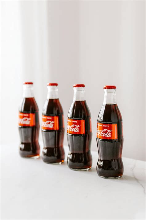 Bottles of coke placed on white surface · Free Stock Photo