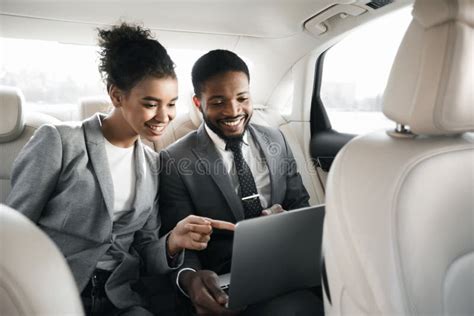 Successful Businessman and Businesswoman Using Laptop Sitting in Luxury Car Stock Photo - Image ...