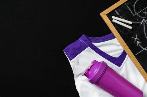 Uniforme Esportivo Branco E Roxo E Garrafa De Gua Ao Lado De Um Quadro