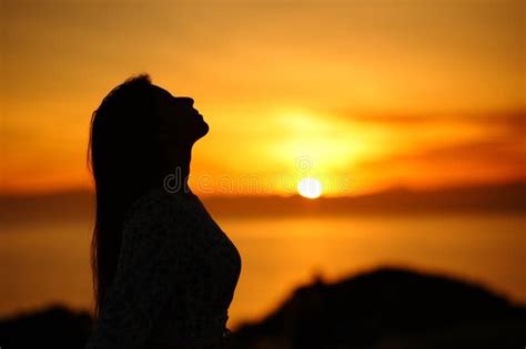 Silhouette Of A Woman Breathing At Sunset Or Sunrise Stock Photo