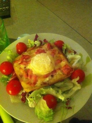 A White Plate Topped With Salad And An Egg On Top Of Lettuce Next To A