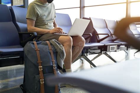 Asian Man Male Air Traveler Sitting In Airport Waiting Area Using