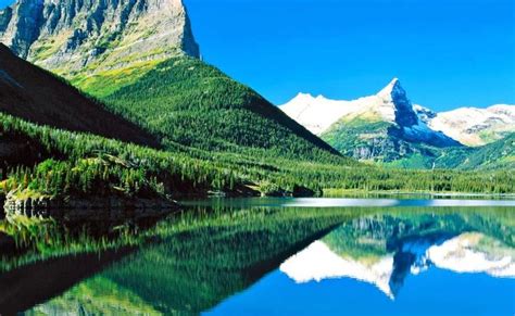 The Mountains Are Reflected In The Still Water