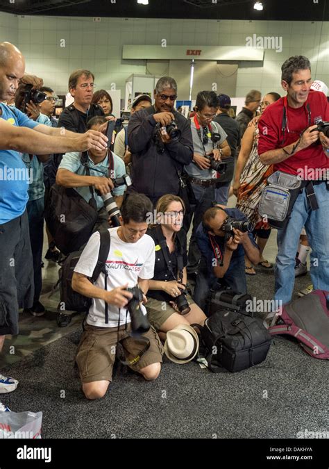Under Studio Lighting Amateur Photographers Crowd Photograph A Model During A Photo Opportunity