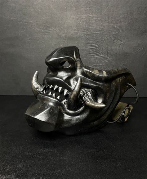 a metal mask that is shaped like a demon's head with fangs on it