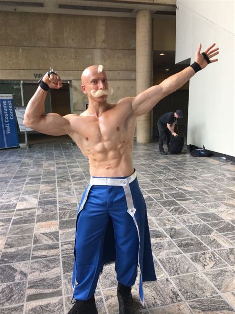 A Man In Blue Pants And No Shirt Is Posing For The Camera With His Hands Up