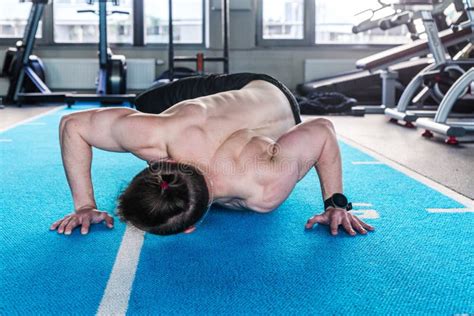 A Naked Torso Man In The Gym Does Push Ups Touching The Floor With His