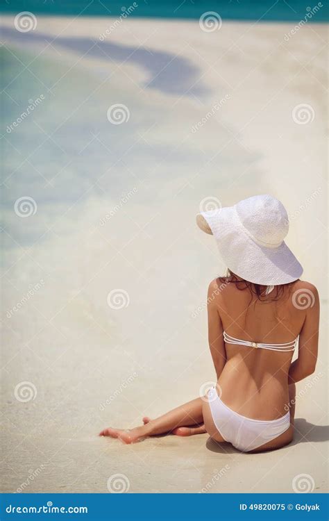 Beautiful Woman In A White Bikini And Hat On The Beach Stock Image