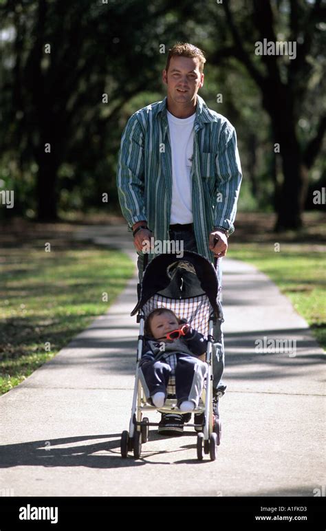 Father Pushing His Infant Son In A Stroller Stock Photo Alamy