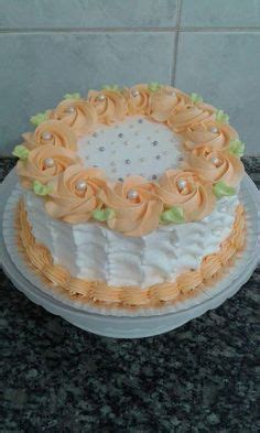 A White And Orange Cake With Flowers On It Sitting On A Counter Top