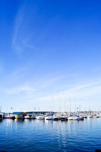 Premium Photo Boats Moored At Harbor Against Blue Sky