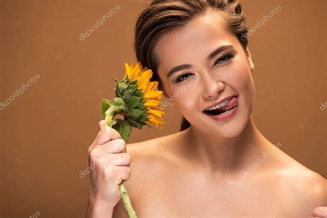 Hermosa Mujer Desnuda Joven Con Girasol Amarillo Sobresaliendo Lengua