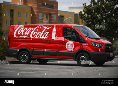 Vans Branded With Coca Cola Logos Sit Outside A Coca Cola Bottling