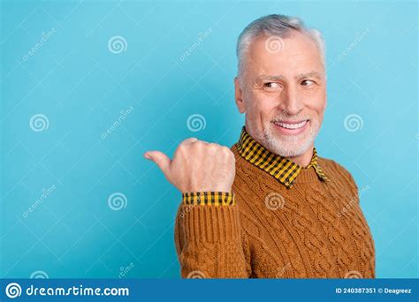 Photo Of Pretty Funny Retired Man Wear Brown Sweater Pointing Empty Space Isolated Blue Color