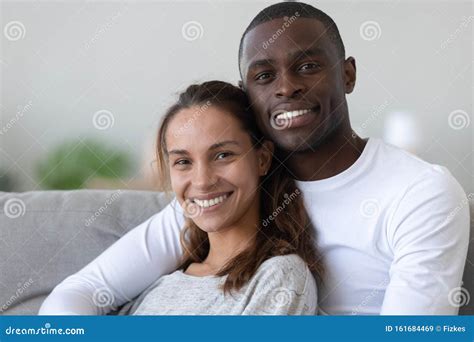 Portrait Of Happy International Couple Relaxing On Couch Stock Image