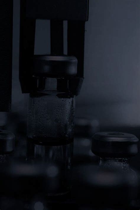 There Is A Glass With Water In It On The Counter Top Next To Some Jars