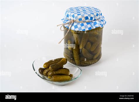 Pickled Gherkins In Jar And Glass Plate Isolated On White Background