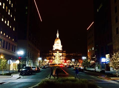 two people are walking down the street in front of some buildings at ...