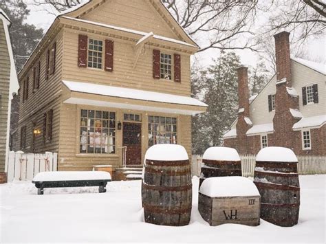 Three Wooden Barrels Sitting In Front Of A House On A Snowy Day With