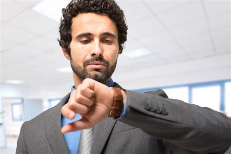 Retrato De Un Hombre De Negocios Mirando Su Reloj Foto Premium