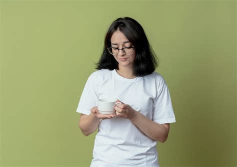 Chica Guapa Joven Disgustada Con Gafas Sosteniendo Y Mirando La Taza