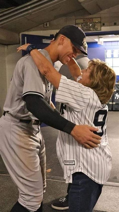 Two Baseball Players Hugging Each Other In The Dugout