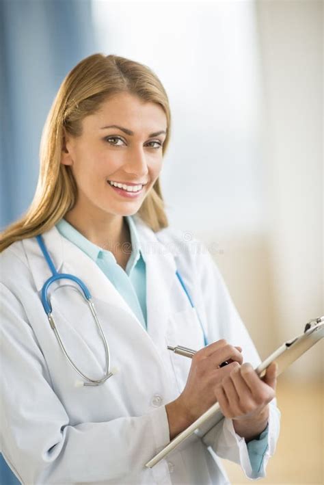 El Doctor De Sexo Femenino Feliz Holding Clipboard Foto De Archivo