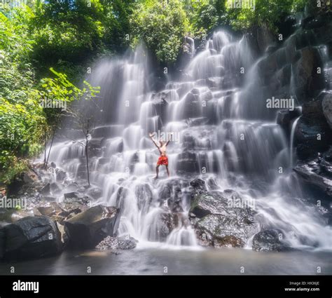 Man Standing In A Waterfall Air Terjun Kanto Lampo In Ubud Bali