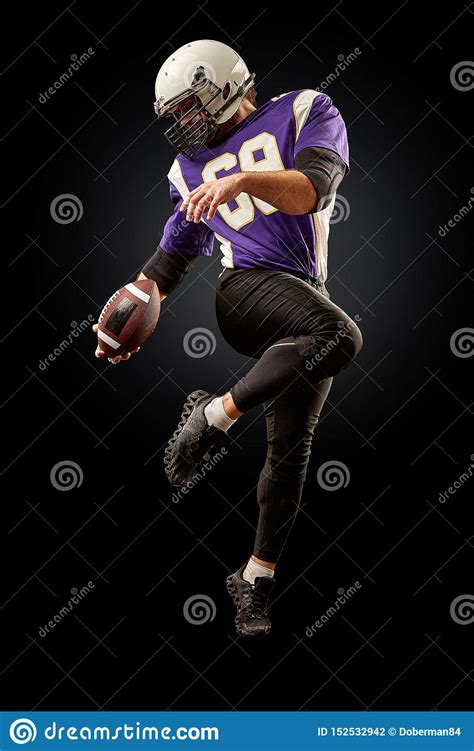 American Football Player Holding a Ball while Jumping Away from a ...