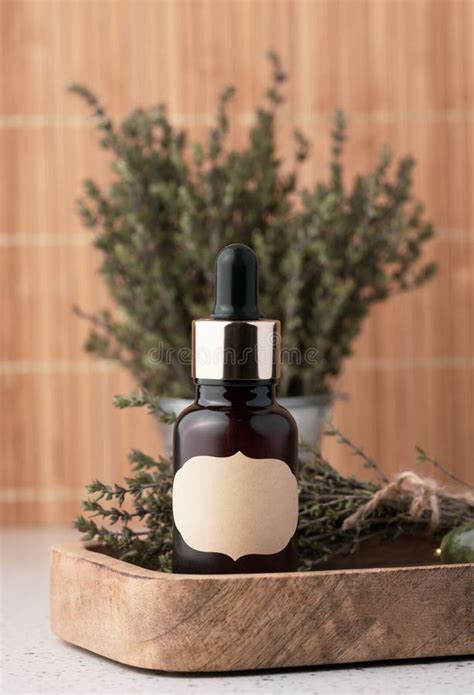 Thyme Essential Oil In Glass Bottle With Dropper And Fresh Thyme Sprigs