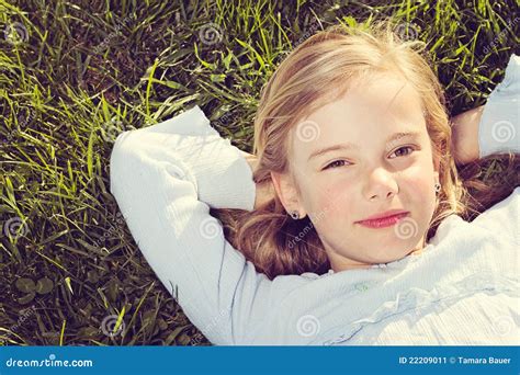 Menina Que Encontra Se Na Grama Imagem De Stock Imagem De Atrativo