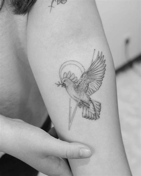 Fine line dove tattoo on the inner forearm.