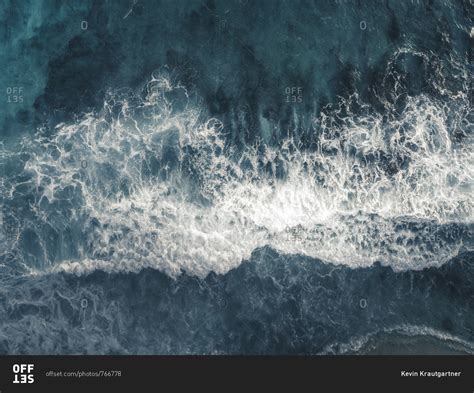 Bird's eye view of waves splashing in the ocean stock photo - OFFSET