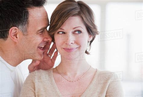 Man Whispering To Woman S Ear Stock Photo Dissolve