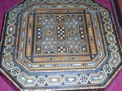 An Intricately Designed Wooden Box Sitting On Top Of A Purple Cloth