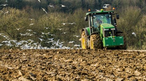 Le Tracteur Moderne De John Deere Tirant Une Charrue A Suivi Des