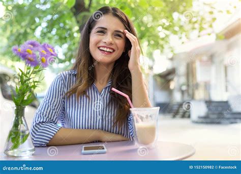 Beautiful Smiling Girl Drinking Coffee In The Cafe Outdoors Stock Photo