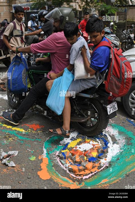 A Motorcyclist Rides Past A Pothole Painted In Different Colors In