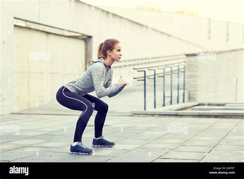 Woman Doing Squats And Exercising Outdoors Stock Photo Alamy