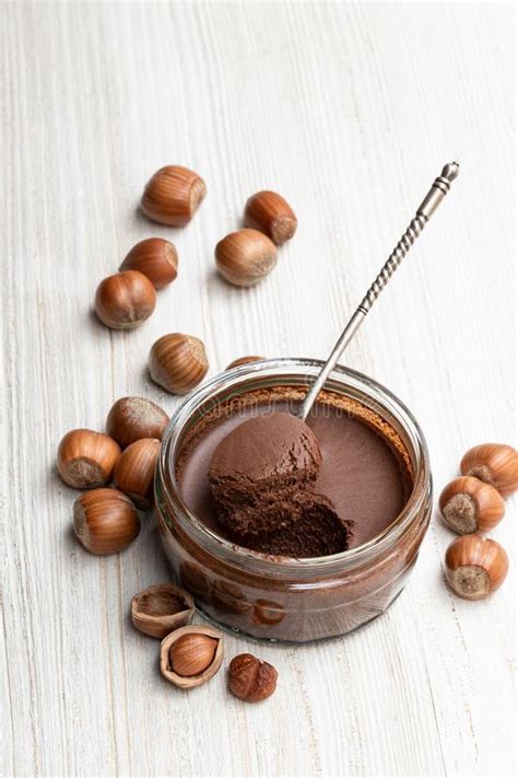 Homemade Chocolate Hazelnut Praline In Glass Jar On White Wooden Table