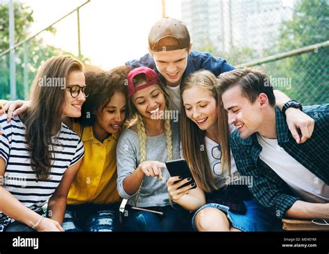 Amigos En El Parque Mirando Utilizando Smartphones Y Milenaria Cultura