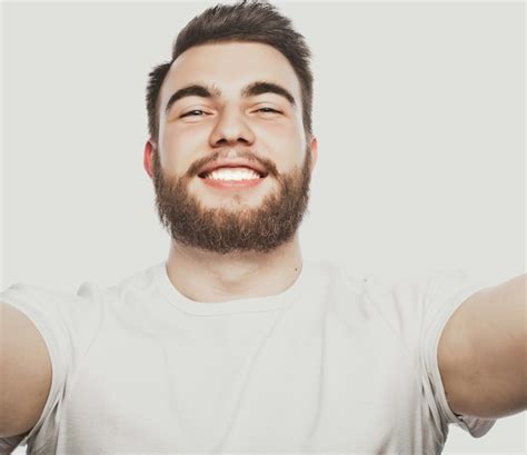 Concepto de tecnología selfie feliz apuesto joven sosteniendo la