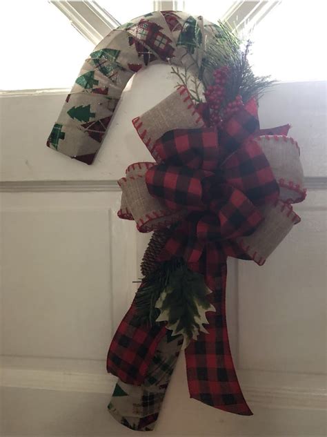 A Christmas Wreath Hanging On The Side Of A Door With Plaid Ribbon And