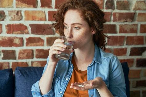 Premium Photo Young Man Drinking Coffee While Sitting Against Brick Wall