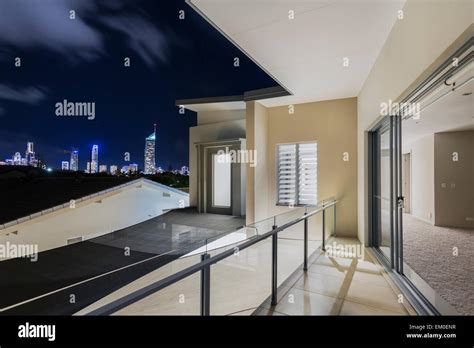 Master Bedroom With Balcony Overlooking City Skyline At Night Over