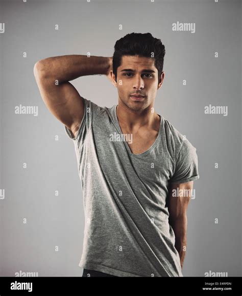 Portrait of handsome young man posing against grey background. Hispanic ...