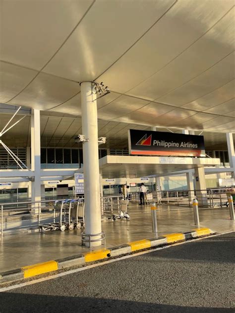 an airport terminal with people waiting for their luggage