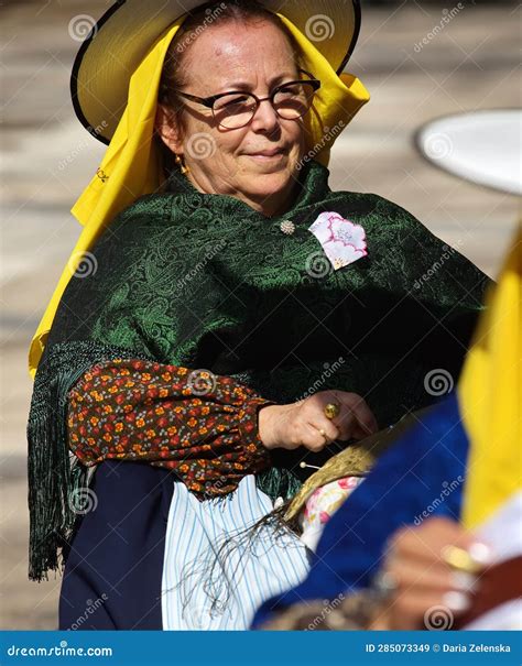 Old Spanish Woman With A Big Hat And Glasses In The Traditional Costume