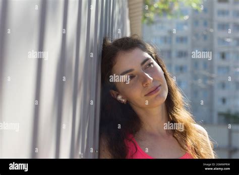 Serene Young Woman Leaning Against Wall Stock Photo Alamy